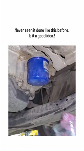 vyro.clip on Instagram: "- The video depicts a DIY oil change on a lifted vehicle, featuring pink gloves for grip, catching residual oil in a plastic cup, prefilling the new Fram filter with fresh oil, and using a long rod inserted through the filter’s center for final tightening from below. - Prefilling the filter with oil is a valid practice to minimize dry-start engine wear, backed by oil analysis experiments (e.g., Project Farm’s 2025 test showing 20-30% less initial metal particles), though
