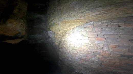 More caves under the city Carrying on our adventure below the streets of Nottingham city centre we enter another set of fantastic old caves but this one was set over three different levels at one point in time . It now has a new block of flats above it and the builders utilised the caves for running waste pipes to the sewers below . At one point in history the caves were definatly used as air raid shelters with remains of benches just about visible on the ground . Two arrows painted on the wall 