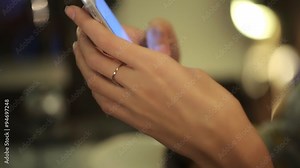 Close up of hands woman with a ring on the finger using her cell phone. indoor.He writes a message or chat with your favorite friends in social networks