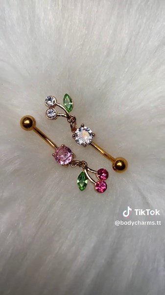 Enhance your style with these stunning gold-tone surgical steel navel rings featuring charming cherry-inspired designs. Adorned with sparkling pink, green, and clear gemstones 💚🍒 PRICE: $50.00 TTD EACH 🤍🍒 BOTH AVAILABLE ✅