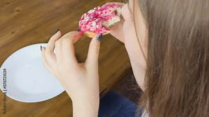 Blonde woman biting one and another donut and enjoying sweet taste