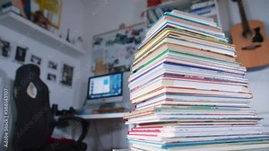 A stack of books in the library office. Round motion of the camera. Learning from paper. Read books.