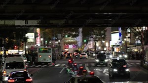 SHIBUYA, TOKYO, JAPAN - NOV 2023 : View of street traffic at night. Many cars, bus, taxi and bike passing by on the road. Japanese transportation and traffic concept video. Out focus shot.