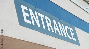 entrance writing caption text facade sign word in white on blue outside exterior outdoors, shot on angle