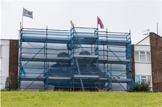 Two masked paramilitary figures painted as work nears completion on infamous UVF mural blown down in Storm Darragh