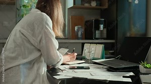 Portrait of stressed woman sitting in kitchen with laptop and stack of paper invoice. Female planning home budget, looking at finance bill and calculating expenses