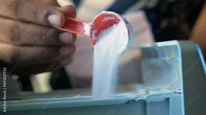 pouring Washing powder in plastic tray of washing machine