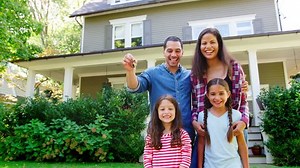 Portrait Of Family Holding Keys To New Home On Moving In Day