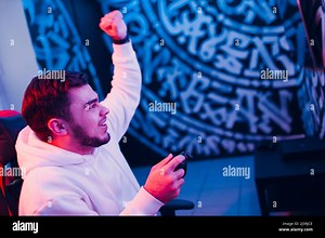 Guy young adult man gamer playing video game on game console at computer gaming club or home Stock Photo - Alamy