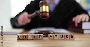 Woman in law attire strikes with gavel against phrase Child Abuse. Concept of child abuse and parents neglect in court slow motion