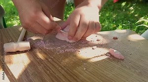A child plays an archaeologist. He gets treasures using various tools - a hammer and others. Hands close-up. Children's games for future professions.