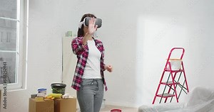 Portrait of modern attractive young asian woman wearing VR headset using augmented reality to design renovation of apartment. Beautiful adult female using new technologies.