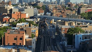 Elevated train track system in downtown Chicago, Illinois. Long aerial shot with telephoto zoom lens of tracks running through housing neighborhoods and suburbs of Chicago.