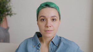 Close up view of woman with blue hair with eyes closed, the opens her eyes and looks at camera Free Stock Video Footage