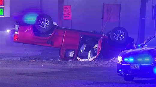 Truck crashes into pole, lands upside down