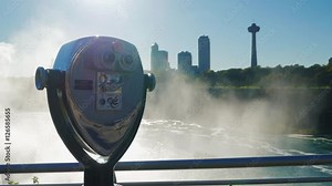 A coin operated binocular viewer located in Niagara Falls with a view to the falls out of focus in the background.