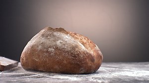 Free stock video - Super slow motion freshly baked loaf of bread falling on a table covered with flour. shot with high speed camera at 420 fps
