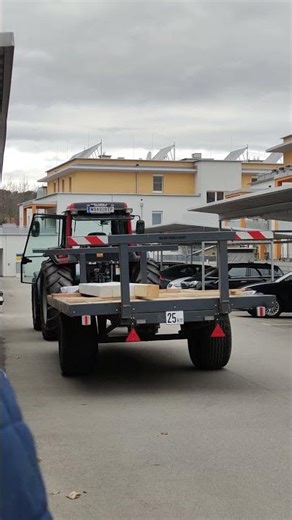 Was macht dieser Traktor hier mit Anhänger am Parkplatz?