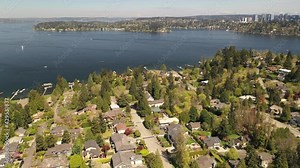 Cinematic aerial drone footage of downtown Mercer island, residential and commercial areas, luxury, beachfront homes in Beaumont by Lake Washington, with Bellevue skyscrapers in the background
