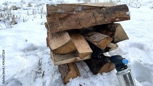 Burning bonfire in frost winter. Campfire in nature, made of dry firewood on white snow. Lighting firewood using gas burner in winter. Lighting a Fire in frost on snow. Hardwood Logs for bonfire