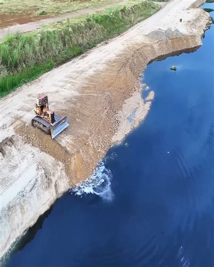 Heavy 25-ton trucks unloading earth and stone to reclaim land by the lake with a bulldozer | Excavator Cambodia I