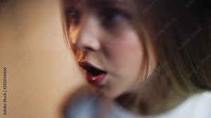 Close up face young blonde girl makes an angry face talk speak white background sad child cute fashion little moody playful studio expression kids portrait slow motion
