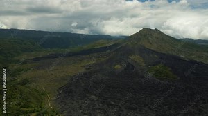 Volcano, mountains, sky with clouds, traces of lava on the ground. Aerial view of Mount Batur Volcano in Kintamani. Bali volcano, also referred to as Kintamani is popular sightseeing destination in