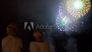 Women Watching Amazing Fireworks in the Night Sky in Slow Motion. Pyrotechnics Show in Italy. The Concepts of Festivals, Holidays and City Celebrations