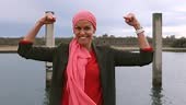 mature woman fighting cancer, wears pink scarf as a sign of fighting...