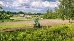 Timelapse. Mini skid steer loader clear the construction site. Territory improvement land work. Small tractor with ground leveler move soil and turf. Agriculture machine. Creation of landscape design.