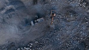 Concrete Recycling and asphalt from demolition. Excavator at landfill the load concrete waste in a mobile jaw crusher machine. Disposal of construction waste. Re-use concrete after demolition.