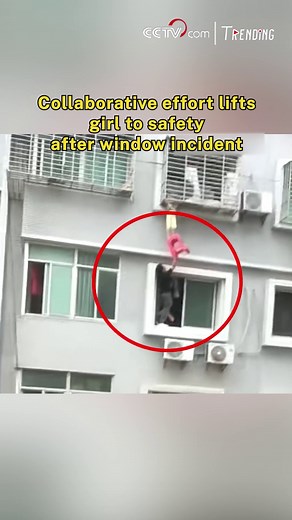 A young girl in Fujian Province was found hanging from a seventh-floor window after getting her head stuck in the security bars. A nearby electrician and his coworker acted instantly. Climbing down one floor, the electrician extended himself out of the window, using a plastic stool to support the girl's feet, proclaiming, "I can hold her indefinitely." Moments later, local patrol officers reached the seventh floor, enabling the team to collaboratively lift the child back inside. #Trending | CCTV