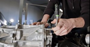 Close-up of mechanic repairing a disassembled electric car engine in a professional auto repair workshop. EV repair concept. Auto Service, Electric vehicle engine maintenance