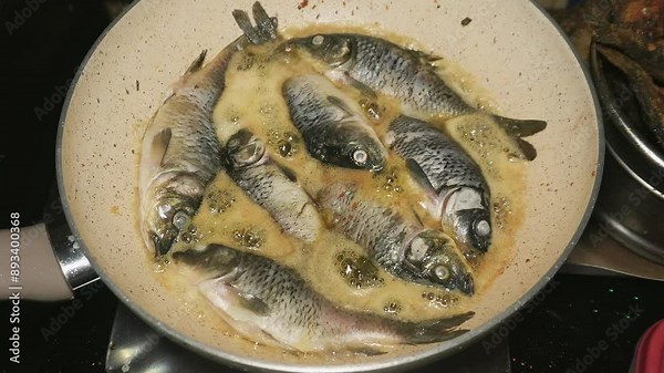 the process of frying several goldfish at once using a frying pan