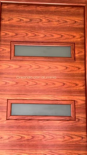 Puerta principal en aluminio tipo madera color cerezo , con cristales satinado y remarcaciones en barrotillo biselado #puertas #colormadera #madera #carpintero #creandoconaluminio | Creando con Aluminio