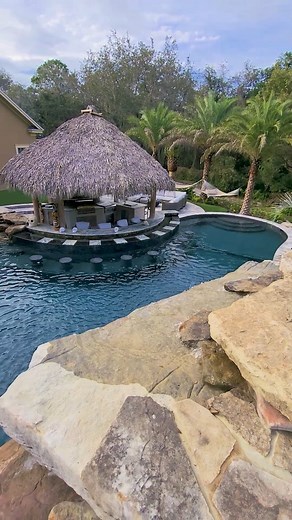 1.5K views · 4.5K reactions | Hands down, one of our most insane builds ever. This backyard features a Tiki Hut outdoor kitchen and swim-up bar, an oversized pool, a huge infinity-edge spa, grottos, upon grottos, upon grottos, with a secret dry cave behind them, and lush tropical landscaping. Pure paradise. #insanepools #lucaslagoons | Lucas Lagoons Design | Facebook