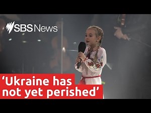 Seven-year-old girl sings Ukrainian national anthem in moving charity event performance | SBS News
