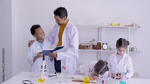 4K, Asian male teacher, standing examining notes, after boy's experiment, within science class, whether wrote correctly taught or not, smiled contentedly when boy, doing what taught correctly wisely.