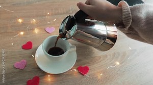 Woman pouring coffee in the cup love hearts background on the table