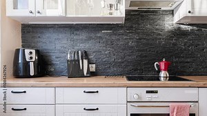 Time lapse of the interior of a kitchen where the sun rays run through the dark rock wall, the counter is made of wood and there are some appliances and knifes on the counter. Stock Video