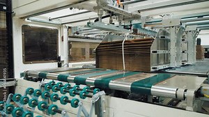 Modern automatic conveyor line for packing cardboard boxes. Factory for producing boxes from corrugated cardboard. Finished boxes are sent to the warehouse for storage and shipment to the customer.