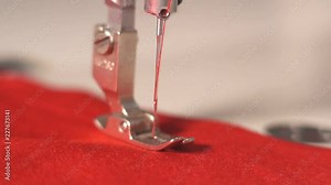 working macro detail of the sewing machine. the needle moves and sews the fabric. the cutting of the material at a textile factory