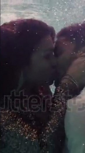 romantic couple kissing underwater in swimming pool
