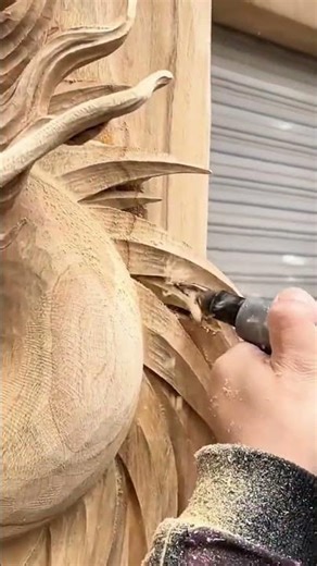 carving intricate patterns on large wood surface using an electric rotary tool for fine finishing