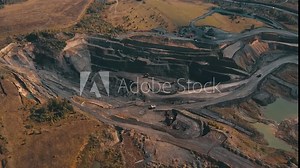 Viewing an openpit mining site with machinery and excavation in natural landscape