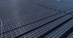 Sunny Emissions: Aerial Expedition of a Solar Panel Factory amidst Nature's Beauty, Highlighting Sustainable Energy Production and Environmental Harmony. High quality 4k footage