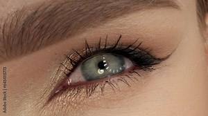 Blue eye close up. Eye iris slow motion. Macro Shot Opening and Closing Blue Eyes. Eye blink slow motion.