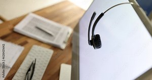 Headphones with microphone keyboard and computer on desktop. Remote work operator