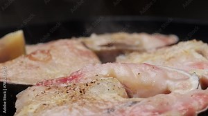 Cooking fillet sturgeon fish on grill or frying pan with oil close-up. Roast healthy food concept. Fry sturgeon, hake, cod fish steak pieces fillet with spice. Healthy diet food