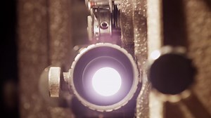 Download Close up of 8mm movie projector, with detail of the lens and flashing light in 4K for free